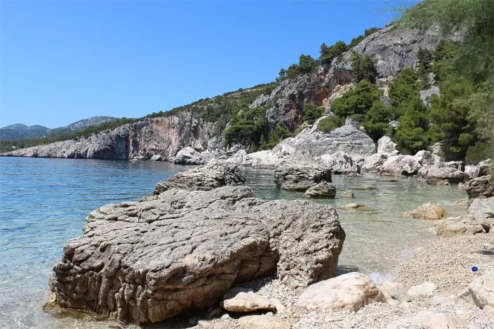 Beach Zarace mit felsigen Klippen und klarem Wasser, umgeben von mediterraner Landschaft.