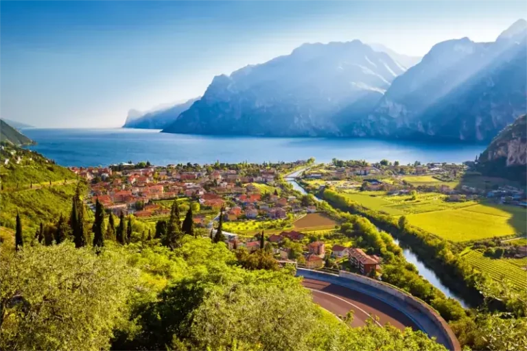 Blick auf die Stadt Torbole und den Gardasee bei Sonnenuntergang.
