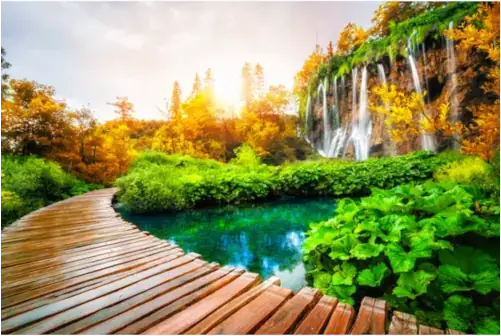 Wunderschöner Holzpfad für Naturwanderungen mit Seen und Wasserfalllandschaft im Nationalpark Plitvicer Seen, UNESCO-Weltnaturerbe und berühmtes Reiseziel Kroatiens.