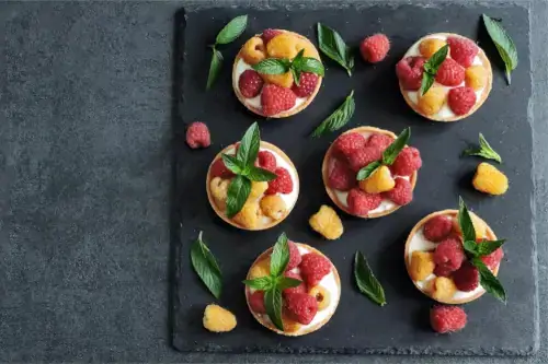 Leckere Desserts mit gelben und roten Himbeeren. Keto-Desserts.