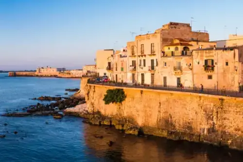 Panorama auf die Altstadt von Ortigia bei Sonnenaufgang, mit der Burg Ortigia (Castello Maniace, Castle Maniace) im Hintergrund, Syrakus (Siracusa), UNESCO-Weltkulturerbe, Sizilien, Italien