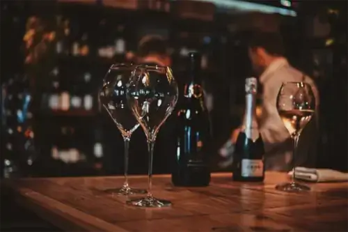 Weingläser auf dem Tisch stehen für eine Weinprobe in einer Kunsthandwerksboutique mit einer großen Auswahl an Alkohol bereit.
