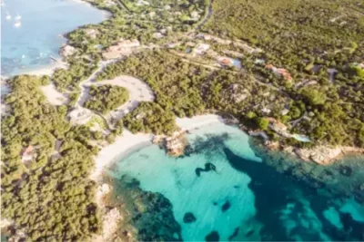 Luftaufnahme vom Strand Capriccioli an der Costa Smeralda auf Sardinien. Meer, Sonne und viel Grün.