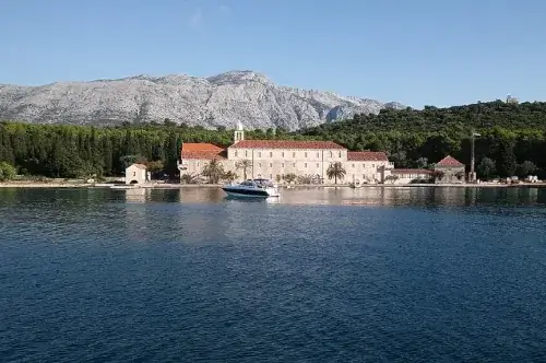 Das Franziskanerkloster auf der Insel Badija, umgeben von üppiger Vegetation und klarem Wasser.
