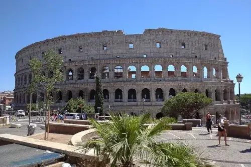 Das Kolosseum in Rom, aufgenommen bei strahlendem Sonnenschein, mit blauem Himmel im Hintergrund.