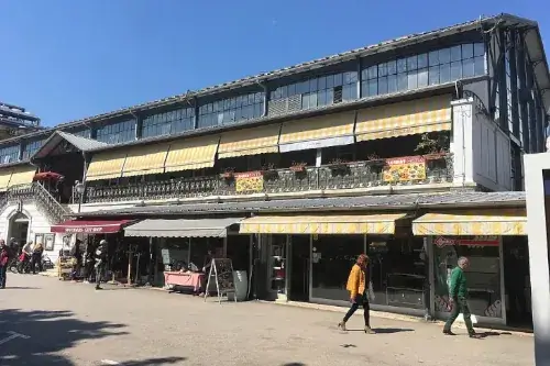Die Markthalle von Pula im Jugendstil, aus Eisen und Glas, mit Ständen für frische Lebensmittel und Cafés.