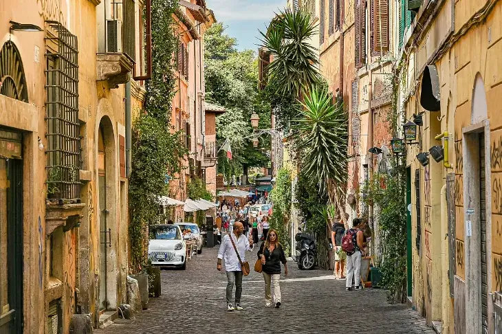 Blick auf eine belebte Straße im Viertel Trastevere in Rom, Italien.