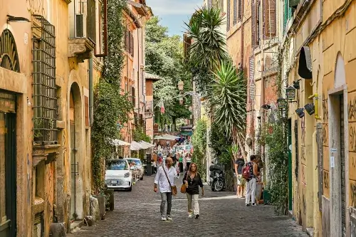 Blick auf eine belebte Straße im Viertel Trastevere in Rom, Italien.