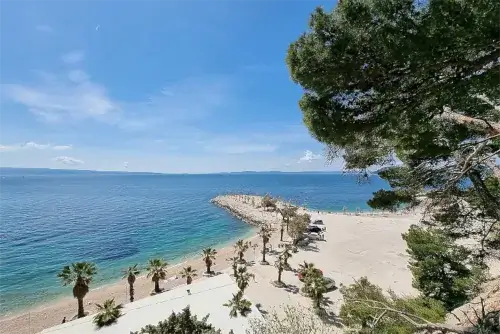 Der Kaštelet-Strand in Split, mit klarem Wasser und von mediterraner Vegetation umgeben.