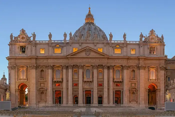 Fassade der Peterskirche im Vatikan während der blauen Stunde.