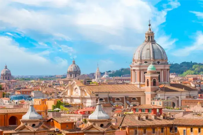Blick auf die barocke Fassade der Basilika dei Santi Ambrogio e Carlo al Corso in Rom mit typischen Wohnhäusern im Vordergrund