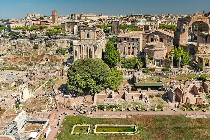 Blick auf das Forum Romanum in Rom mit Tempelruinen und grüner Umgebung.