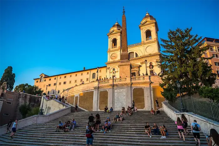 Spanische Treppe in Rom bei Abendlicht mit Blick auf die Kirche Trinità dei Monti.