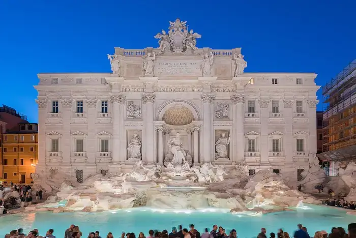 Der Trevi-Brunnen in Rom am Abend, stimmungsvoll beleuchtet mit ruhigem Wasserbecken.