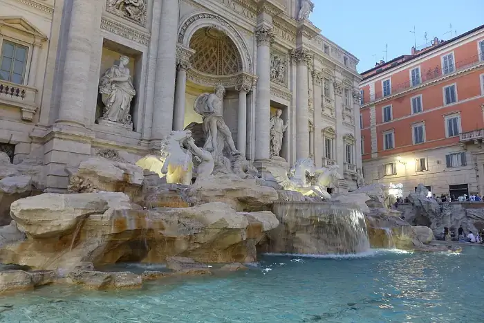 Trevi-Brunnen in Rom am Abend mit warmem Licht und detailreicher Fassade.