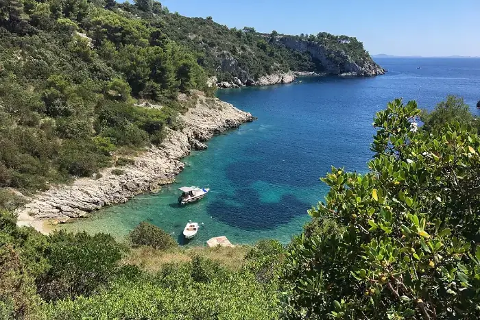 Blick auf die Bucht Uvala Jorja auf der Insel Šolta, umgeben von Felsen und grüner Landschaft.